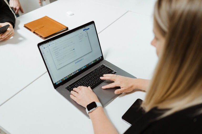 Žena pracuje na notebooku a vybírá CRM systém